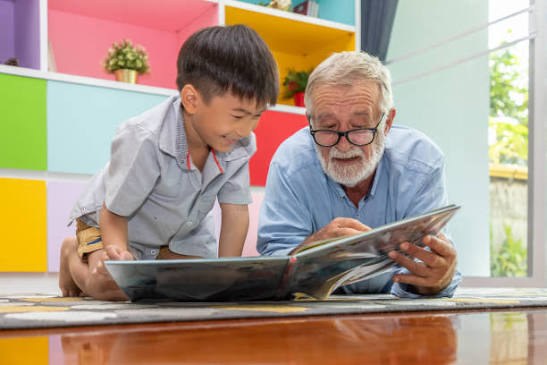Grandfather reading a picture book with his grandson